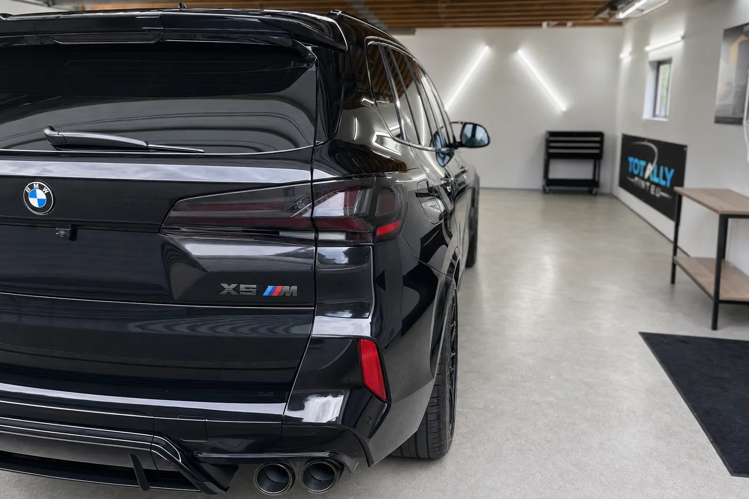 Gloss black BMW X5 M with freshly tinted windows in the Totally Tinted garage studio