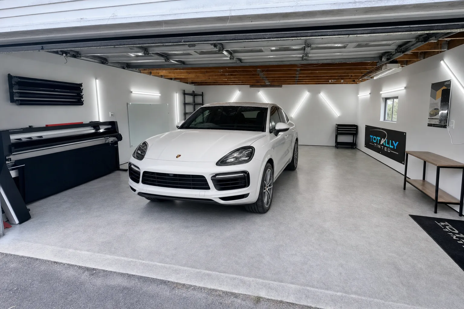 Pearl white Porsche Cayenne Coupe with freshly tinted windows in the Totally Tinted garage studio