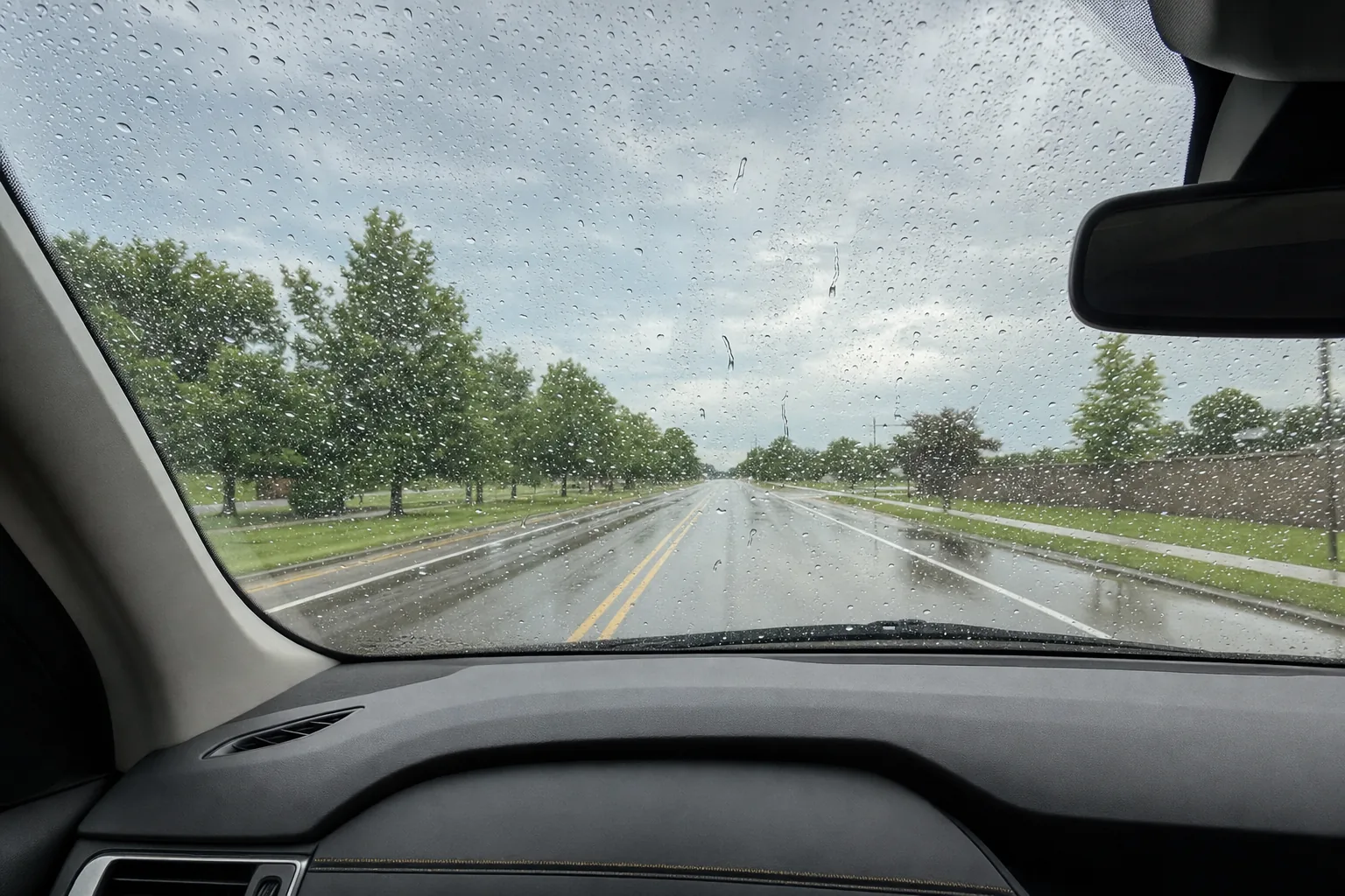 Rain beading on a coated windshield, seen from the driver’s seat